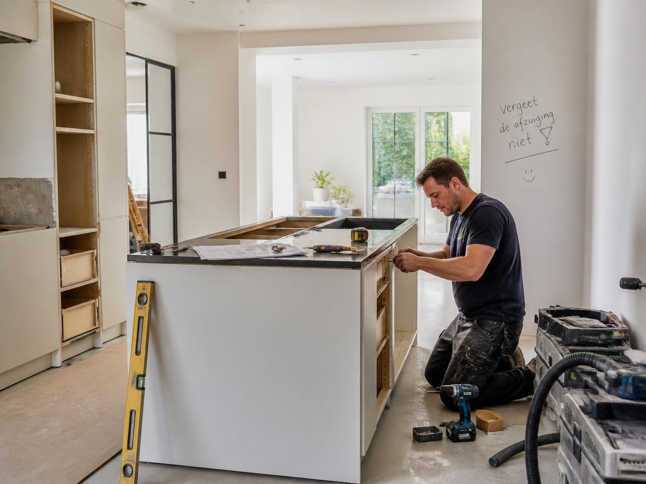 Vakman installeert een nieuwe keuken tijdens een verbouwing